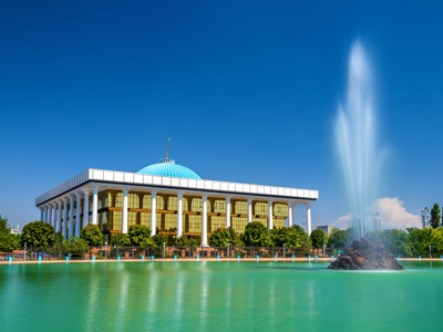 Parlementsgebouw in Tasjkent met blauwe koepel en fontein aan het meer, tijdens de Route Oezbekistan.