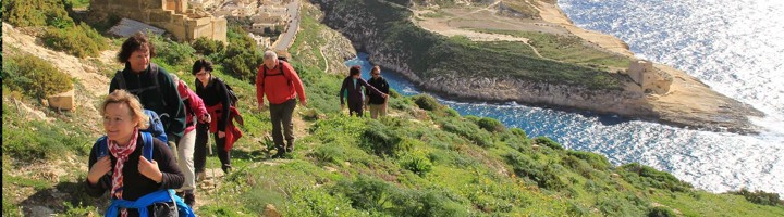 Wandelaars op kustpad langs de rotsen en een baai op Malta.