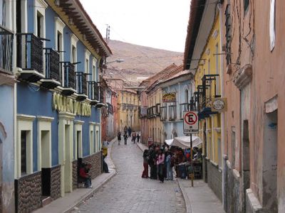 Straat in La Paz met kleurrijke gebouwen en mensen langs de stoep, tijdens de route Argentinië, Bolivia en Peru.