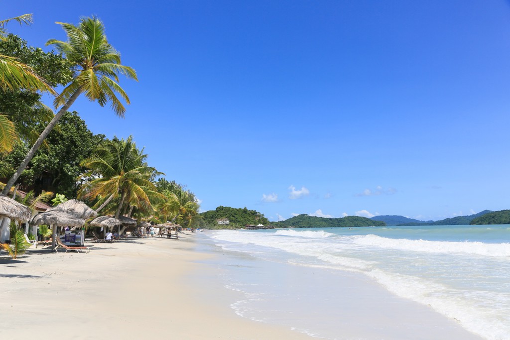Tropisch zandstrand met palmbomen en ruisende golven tijdens groepsrondreis West-Maleisië & Borneo.