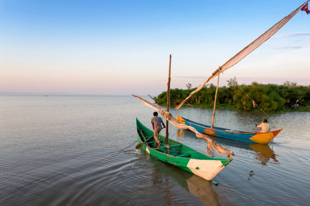 Dhows met zeil op rustig water bij zonsondergang tijdens groepsrondreis Kenia, Tanzania en Zanzibar.