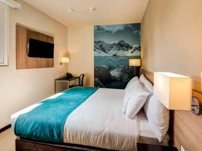 Comfortabele hotelkamer in Arawi Express Miraflores met tweepersoonsbed, bureau en tv.