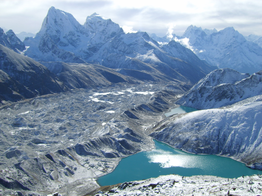 Besneeuwde bergtoppen en gletsjervallei met turquoise gletsjermeer tijdens de Everest-trek in Nepal.