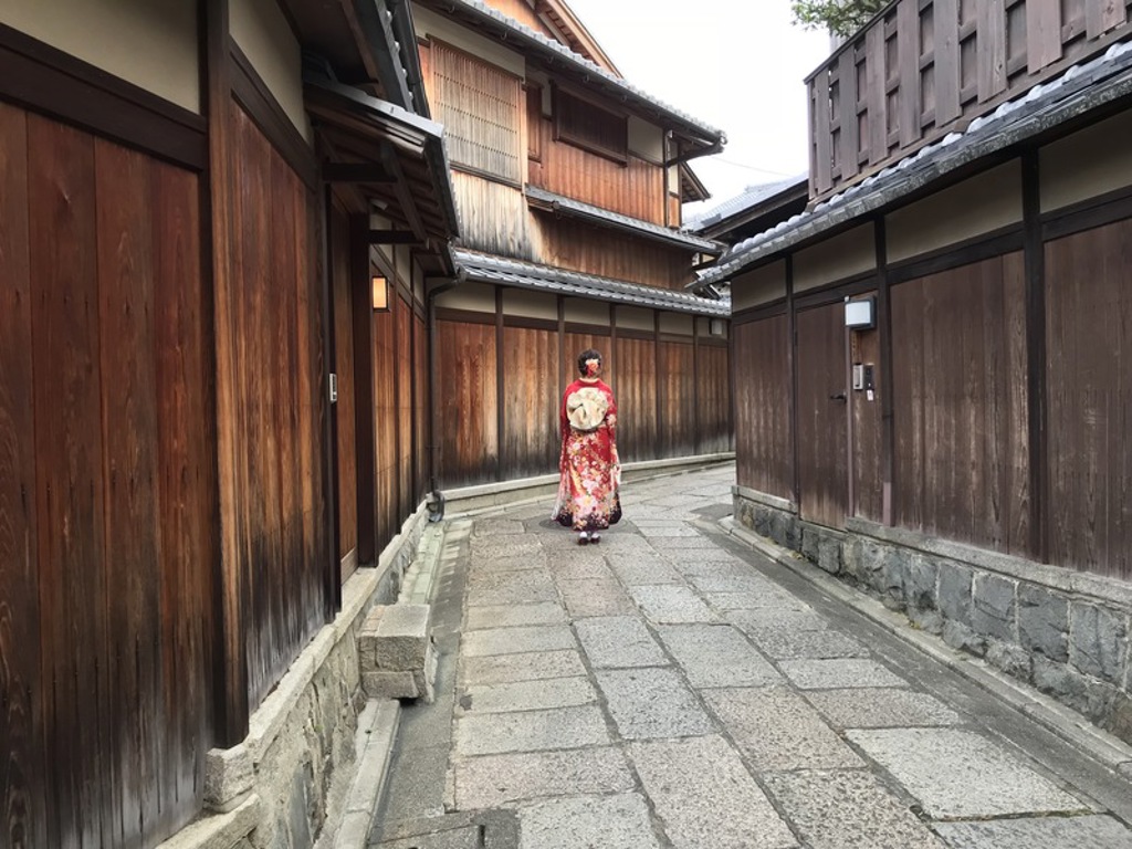 Vrouw in kimono in een traditionele straat in Japan tijdens een familiereis.