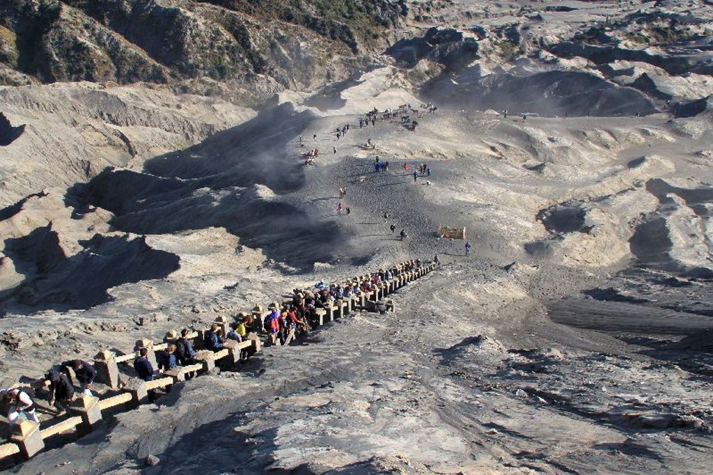 Wandelaars op een pad door het grijze vulkaanlandschap van Java, tijdens een groepsrondreis Java, Bali en Lombok.