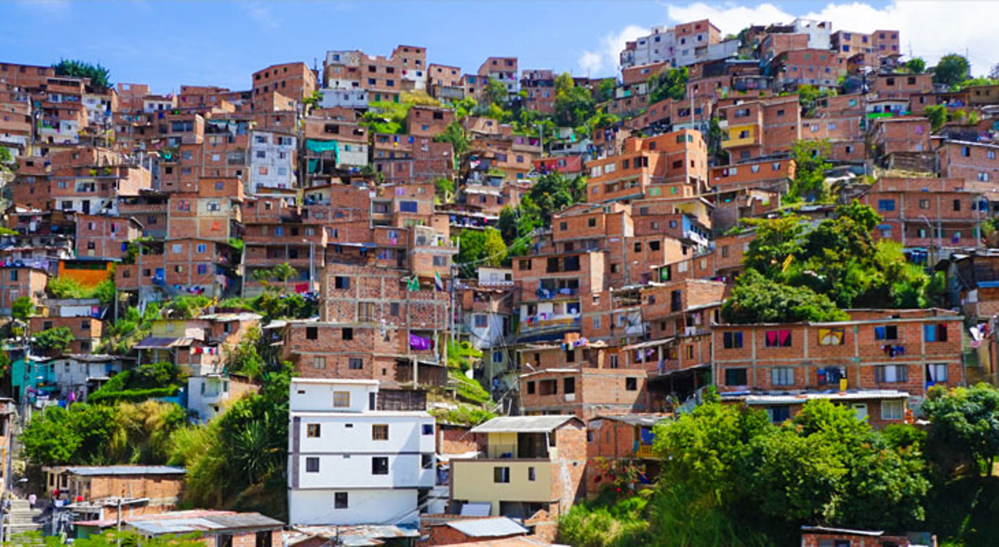 Dichtbebouwde wijk met kleurrijke huizen op een heuvel in Colombia.