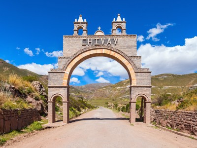 Poort met opschrift “LIVVAY” langs een weg in het Andeslandschap van Peru.