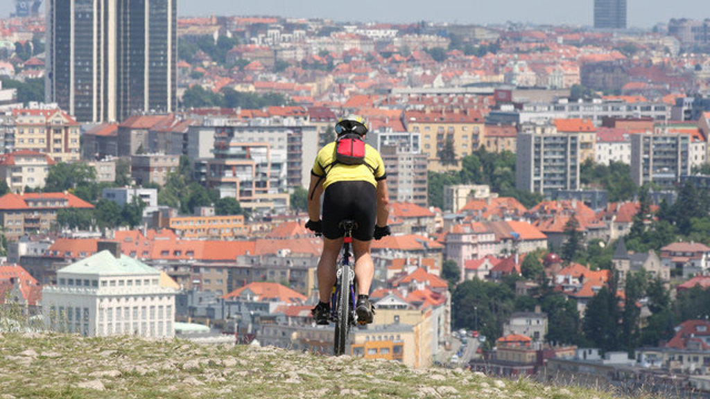 Fietser met uitzicht over Praag tijdens fietsvakantie van Praag naar Wenen.