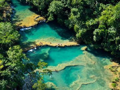 Turquoise waterpoelen van Semuc Champey in Guatemala, omringd door tropisch regenwoud.