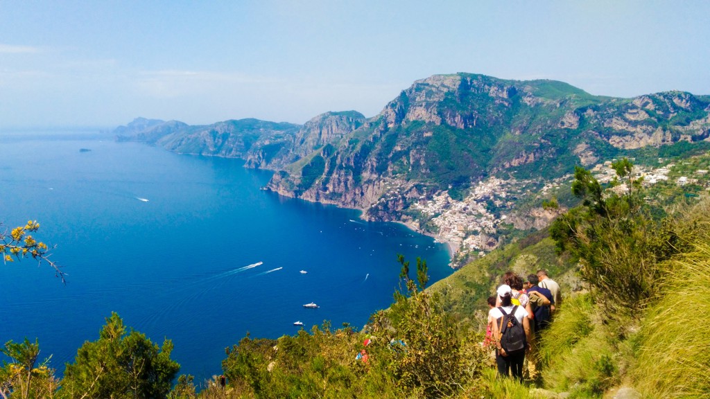 Wandelaars op bergpad met uitzicht op de Amalfikust en Positano aan zee, Italië.