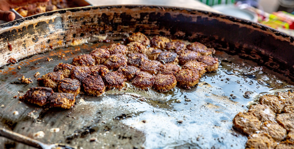 Verse snacks bakken op een hete plaat op straatmarkt in Noord-India.