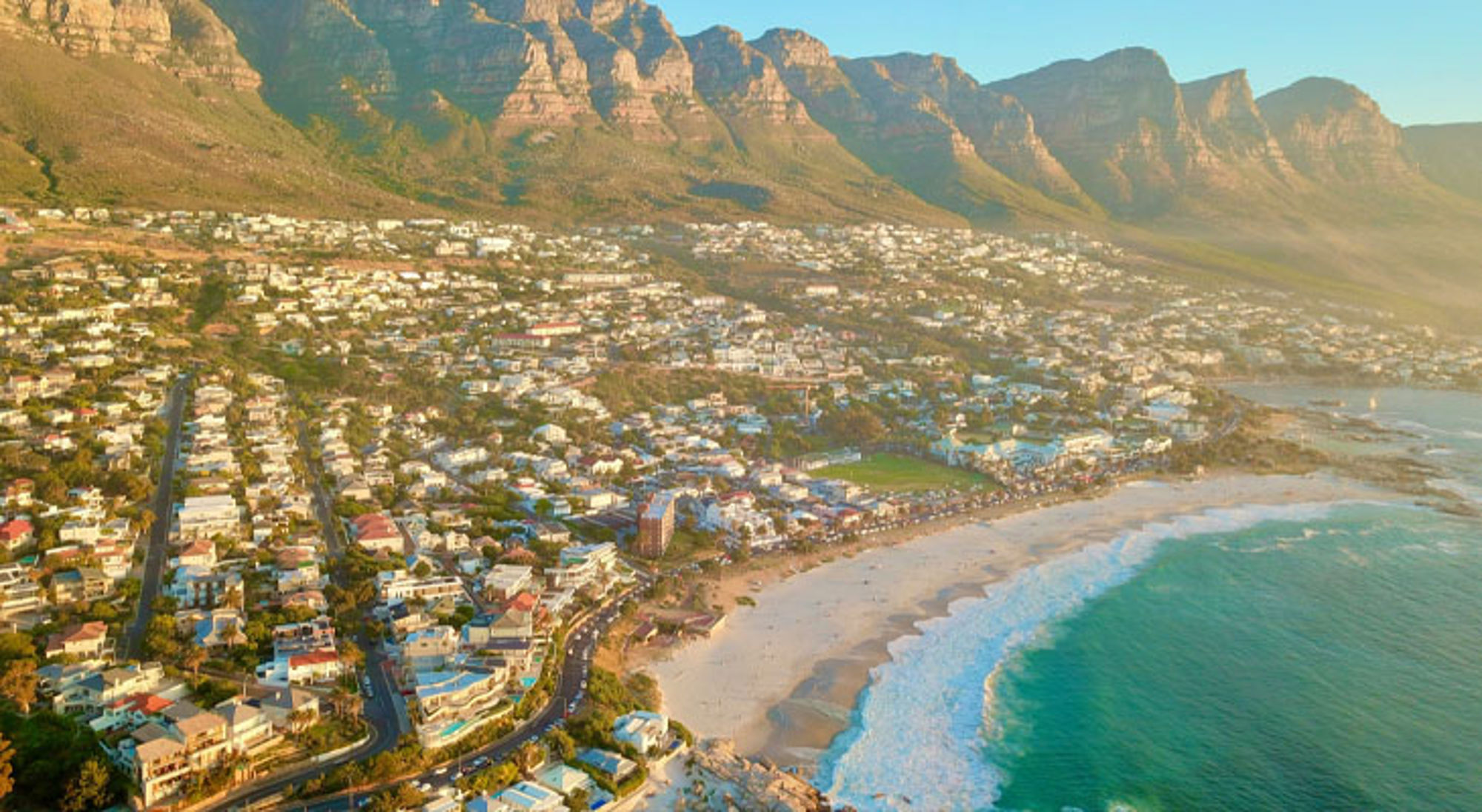 Panoramisch uitzicht op Camps Bay met strand en Tafelberg bij Kaapstad, Zuid-Afrika.
