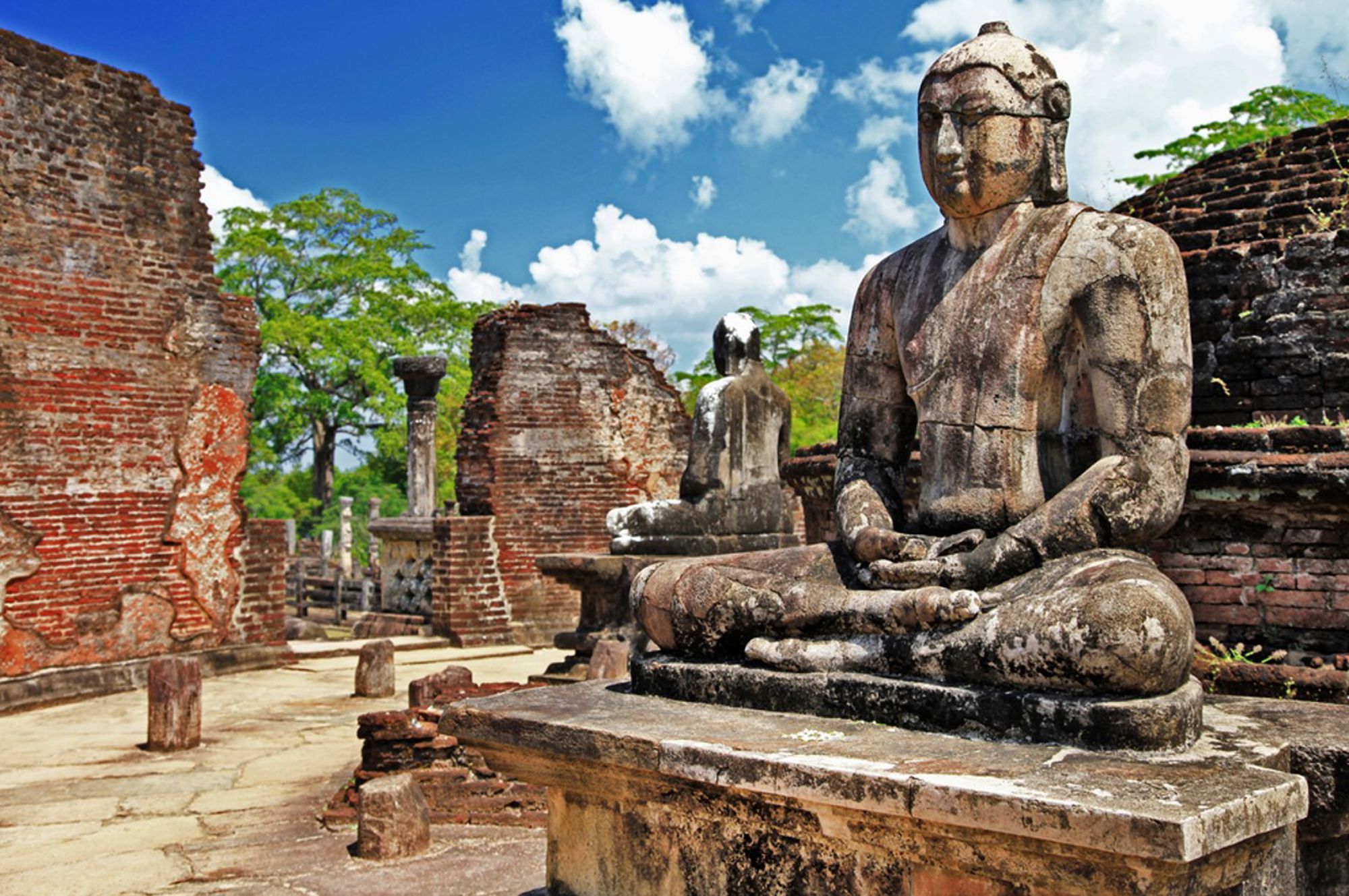 Zittend Boeddhabeeld tussen de ruïnes van de oude stad Polonnaruwa in Sri Lanka.