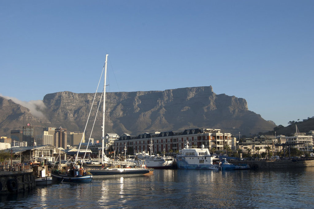 Uitzicht op Table Mountain en de V&A Waterfront in Kaapstad, Zuid-Afrika, met zeilboten in de haven.