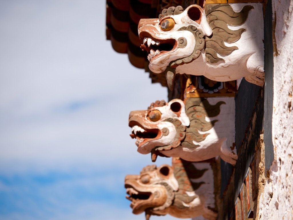 Houten drakenwaterspuwers aan een boeddhistisch klooster in Bhutan, tijdens groepsrondreis Sikkim en Bhutan.