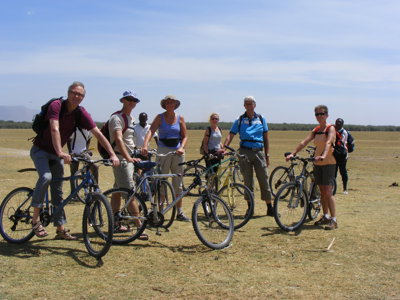 Groep reizigers met mountainbikes op de savanne tijdens de route Kenia, Tanzania en Zanzibar.