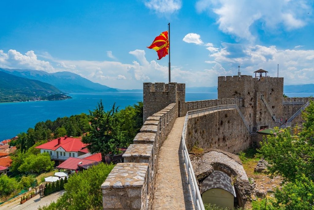 Albanese vlag wappert op een vlaggenmast boven de stad, tijdens groepsrondreis Albanië, Kosovo en Noord-Macedonië.