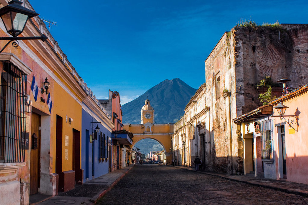 Straat in Antigua Guatemala met de Santa Catalina-boog en vulkaan Agua tijdens groepsrondreis Trans-Midden-Amerika.