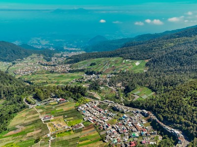 Uitzicht over groene landbouwterrassen en dorp in de bergen op Java, tijdens de route Java en Bali op 22 juli.