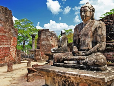 Zittend Boeddhabeeld tussen ruïnes van de oude stad Polonnaruwa, Sri Lanka.