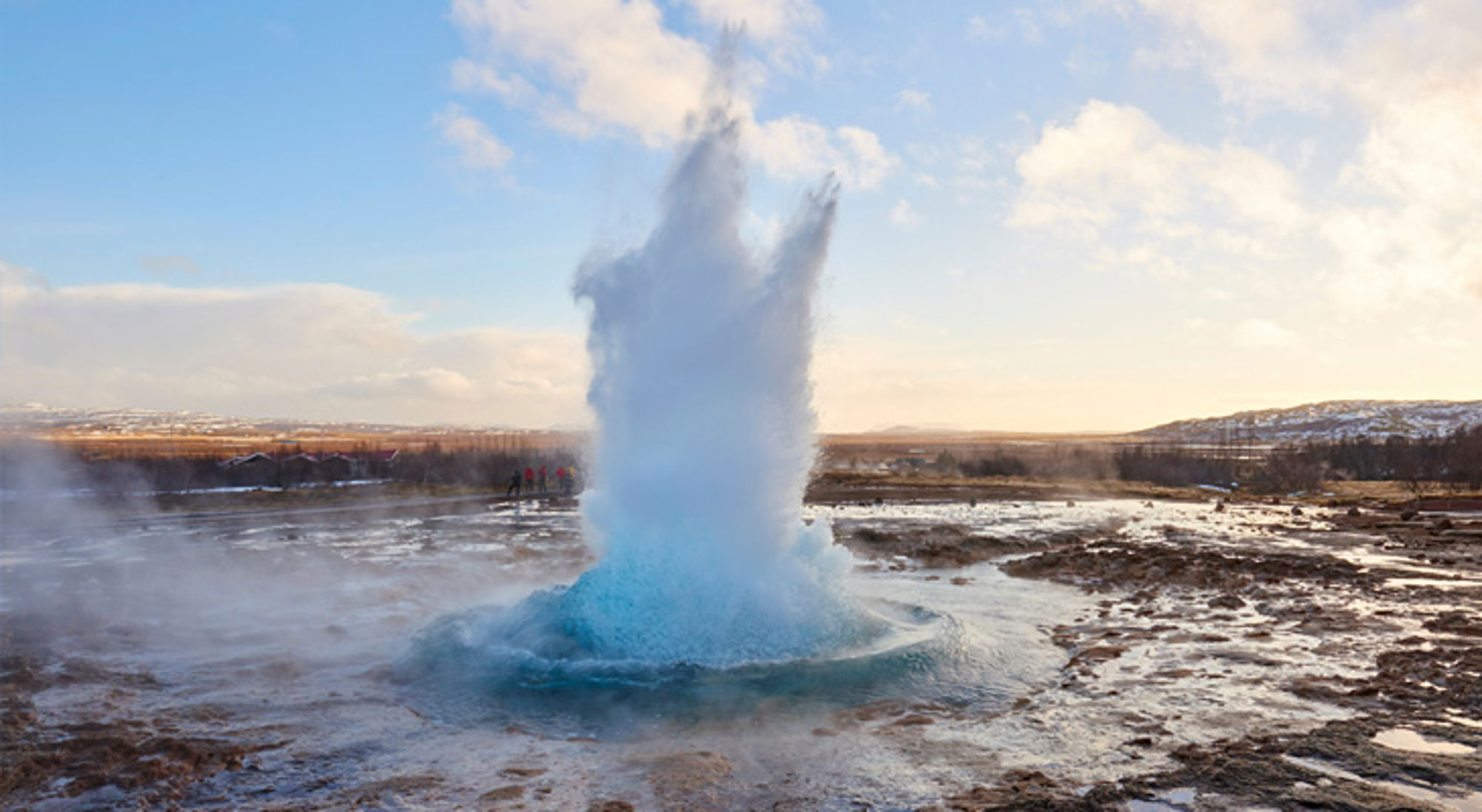Eruptie van de Strokkur-geiser in IJsland, met een hoge waterkolom boven het geothermische veld.