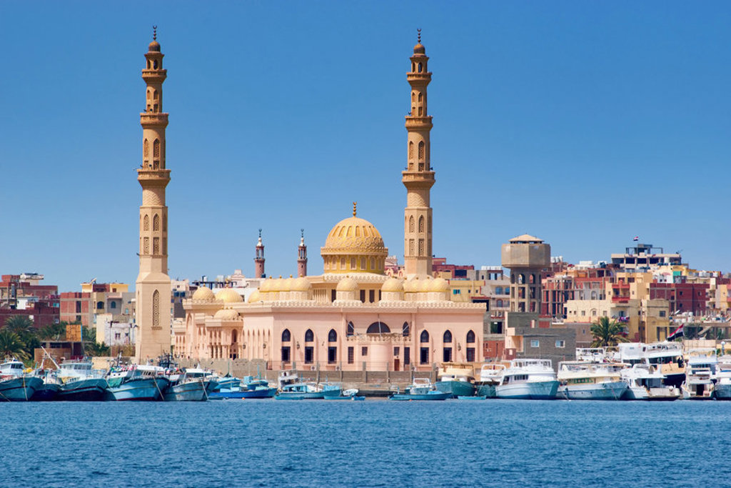 Moskee met twee minaretten aan de haven van Hurghada, Egypte, met boten op de voorgrond.