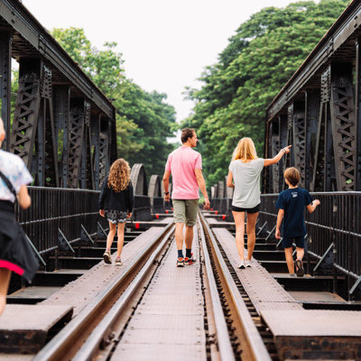 Gezin wandelt over de spoorbrug aan de River Kwai tijdens familiereis Thailand Noord en Zuid.
