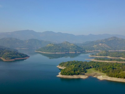 Uitzicht over een groot stuwmeer met beboste heuvels en bergketen in Sri Lanka.