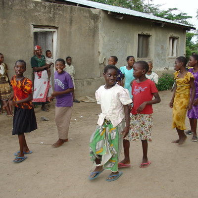 Kinderen en vrouwen bij een huis in een dorp tijdens de groepsrondreis Kenia en Tanzania Totaal.