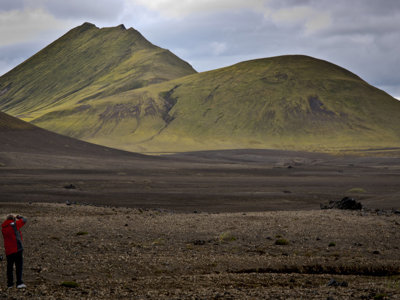 Reiziger fotografeert groen vulkanisch landschap in IJsland tijdens groepsrondreis Route IJsland.