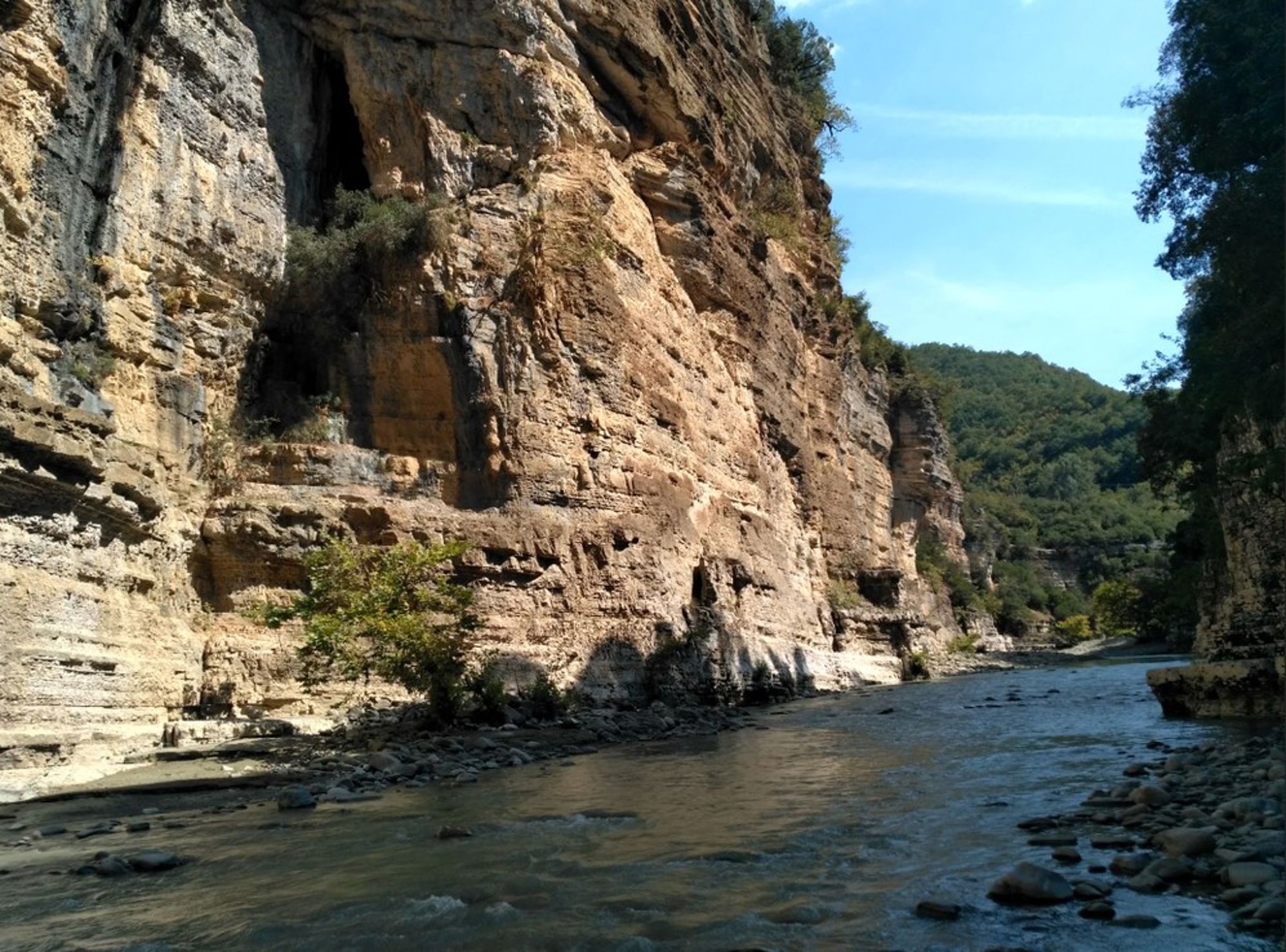Rivier in de Osum-kloof met hoge rotswanden en groene heuvels in Albanië.