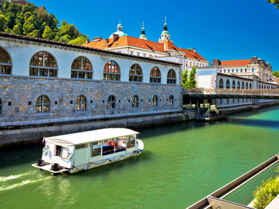 Rondvaartboot op de Ljubljanica langs historische gebouwen in Ljubljana, Slovenië.