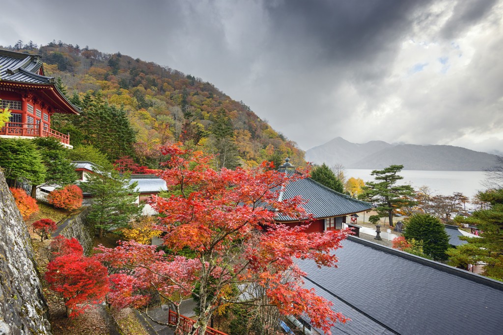 Tempelcomplex bij bergmeer in Japan met rode herfstkleuren, hoogtepunten van een groepsrondreis Japan.