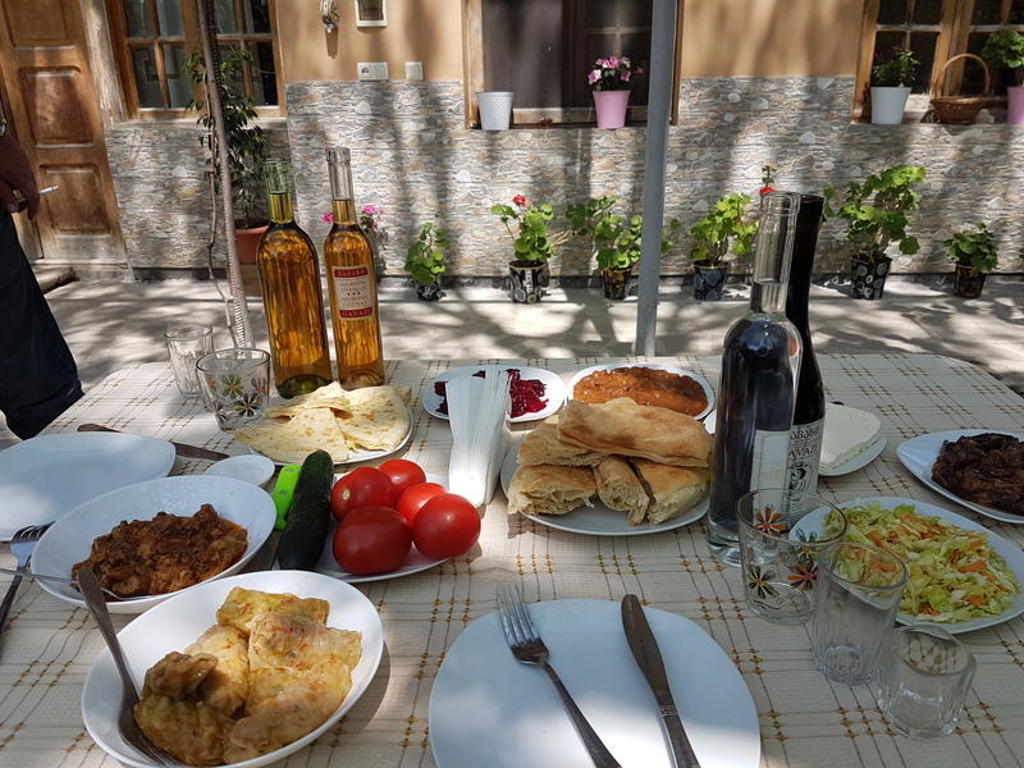Traditionele Georgische lunch met vers brood, tomaten en lokale wijn tijdens een 22-35ers reis door Georgië.