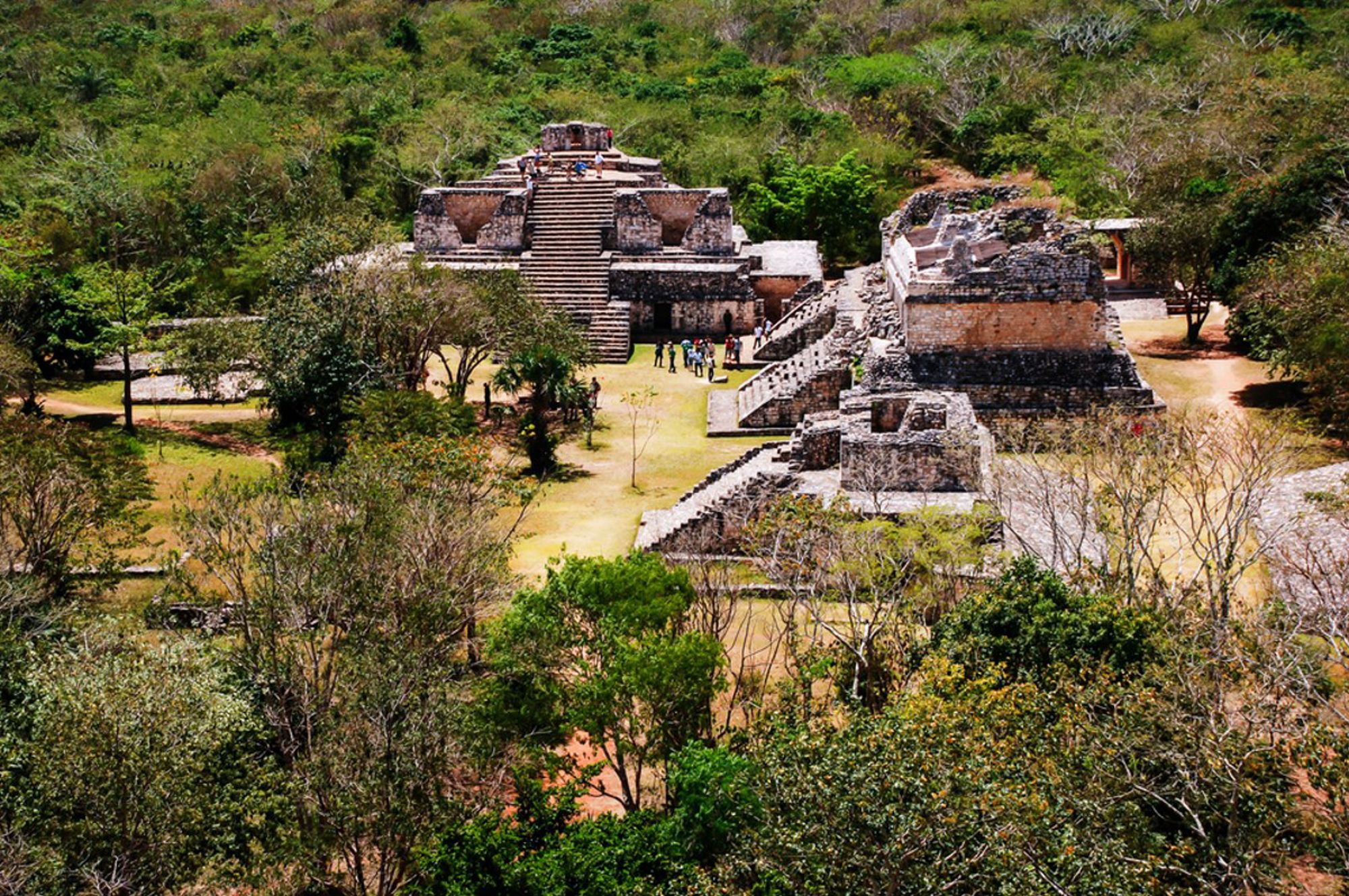 Maya-ruïnes van Uxmal in Yucatán, Mexico, met trappenpiramides tussen groen landschap.