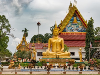 Gouden Boeddhabeeld bij kleurrijke tempel op de route Laos & Cambodja.