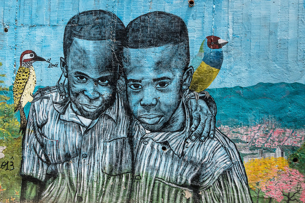 Muurschildering in Colombia met twee jongens en kleurrijke vogels, onderdeel van de groepsrondreis Colombia.