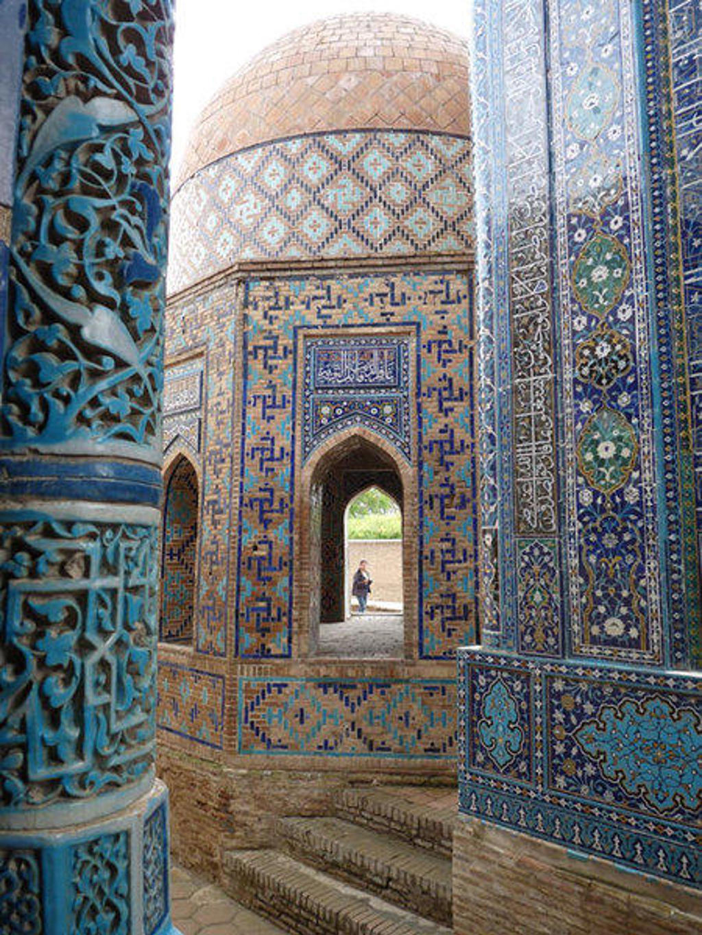 Blauw betegelde moskee met koepel en sierlijke zuilen in Oezbekistan, tijdens een groepsrondreis.