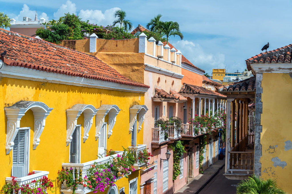 Kleurrijke straat met koloniale gevels en bloeiende balkons in Cartagena, Colombia, tijdens een groepsrondreis.