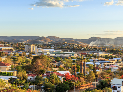Uitzicht over Windhoek met kleurrijke huizen en bergen op de achtergrond, onderdeel van de route door Namibië.