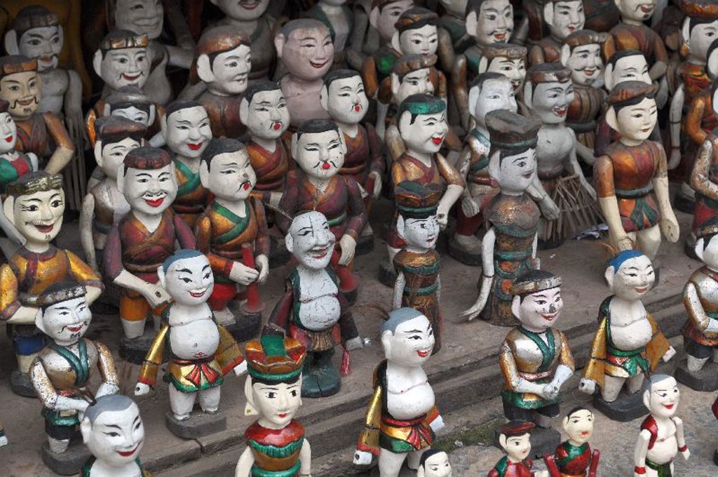 Handgemaakte Vietnamese houten poppetjes op een markt, kleurrijk beschilderd.