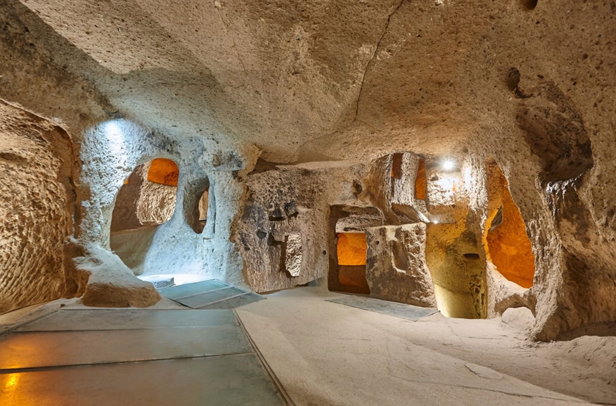 Interieur van een ondergrondse stad in Cappadocië, Turkije, met uitgehouwen kamers en verlichte doorgangen.