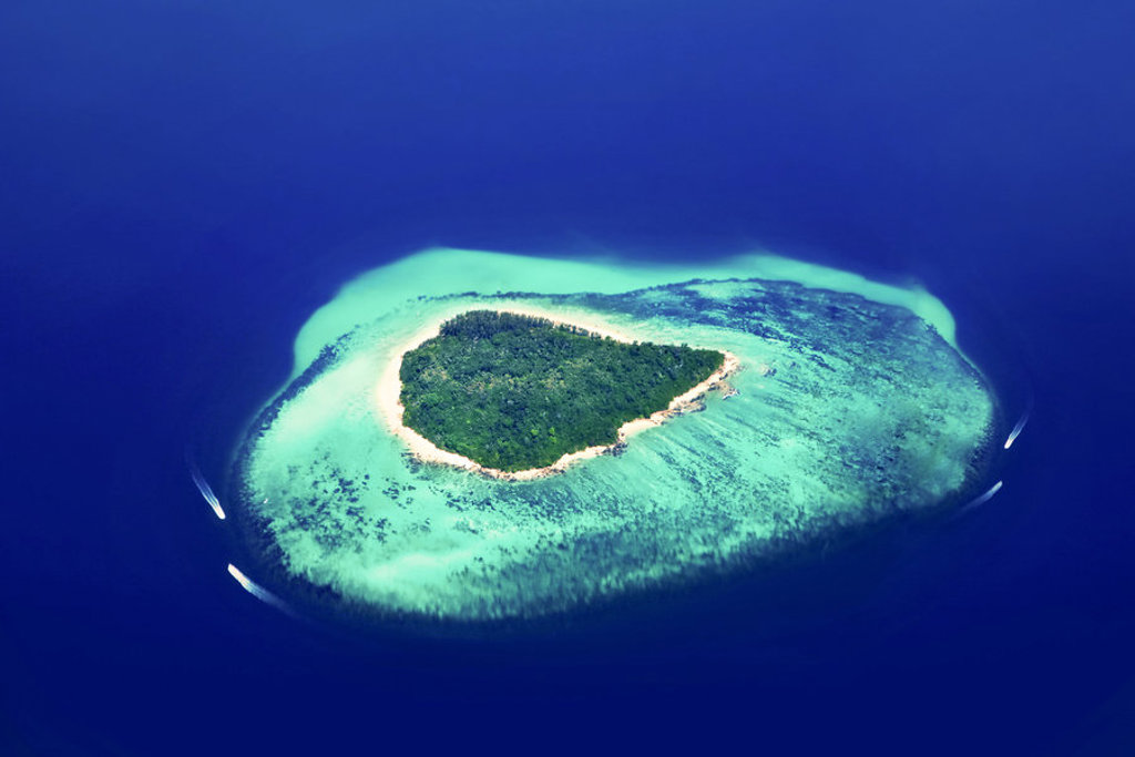 een tropisch eiland met wit zandstrand en turquoise lagune op de Malediven.