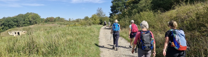 Wandelaars op de Dutch Mountain Trail in Zuid-Limburg, Nederland, over een grindpad door heuvelachtig landschap.