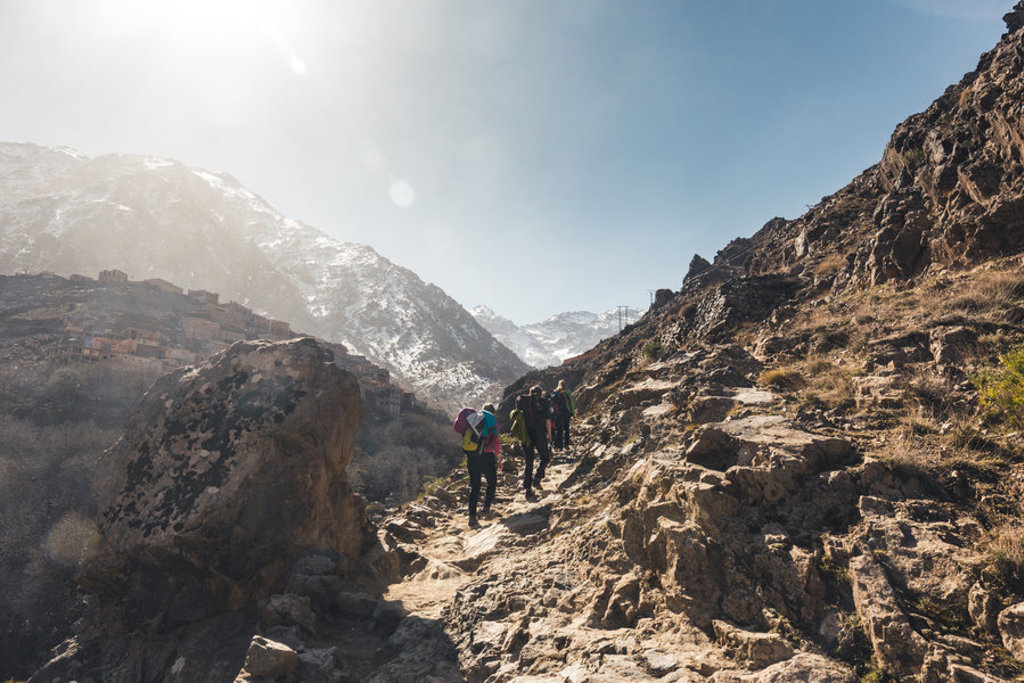 Groep wandelaars op bergpad in het Atlasgebergte tijdens de beklimming van Mount Toubkal in Marokko.