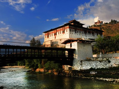 Rinpung Dzong in Paro, Bhutan, met houten brug over de rivier.