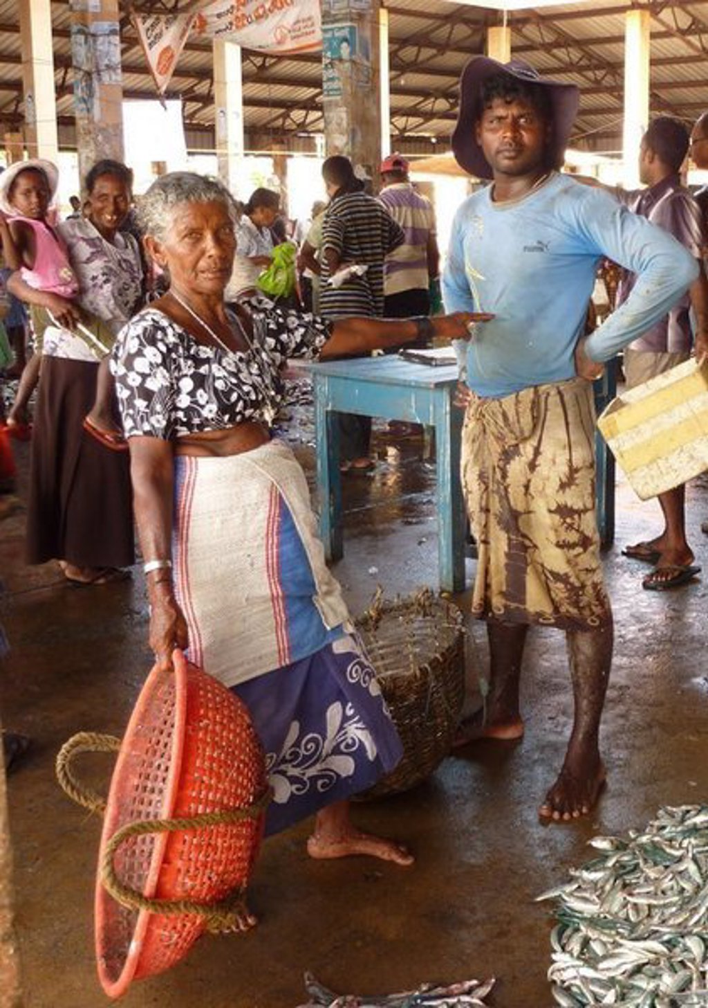 Vissers op een vismarkt in Sri Lanka, met vers gevangen vis op de vloer.