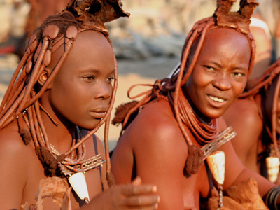 Portret van Himba-vrouwen met traditionele kapsels en sieraden in Namibië tijdens route Victoria Falls–Kaapstad.