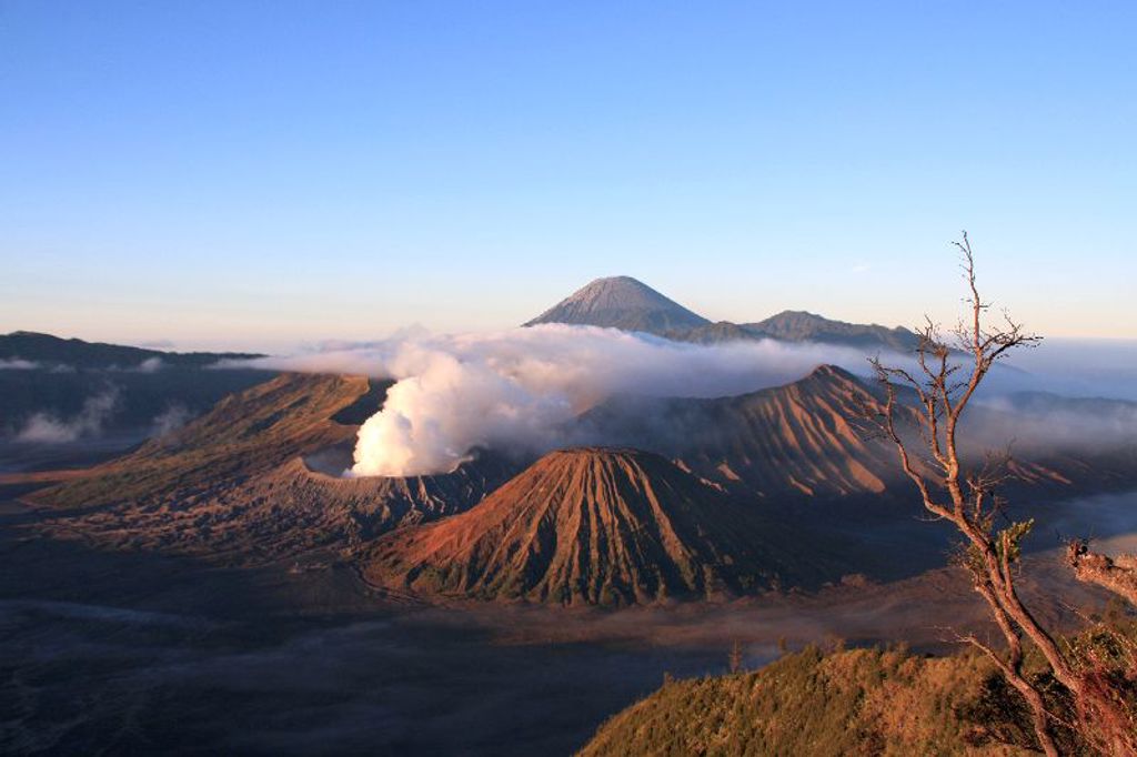 Zonsopkomst bij de Bromo-vulkaan met rokende krater en bergen op Java, Indonesië.