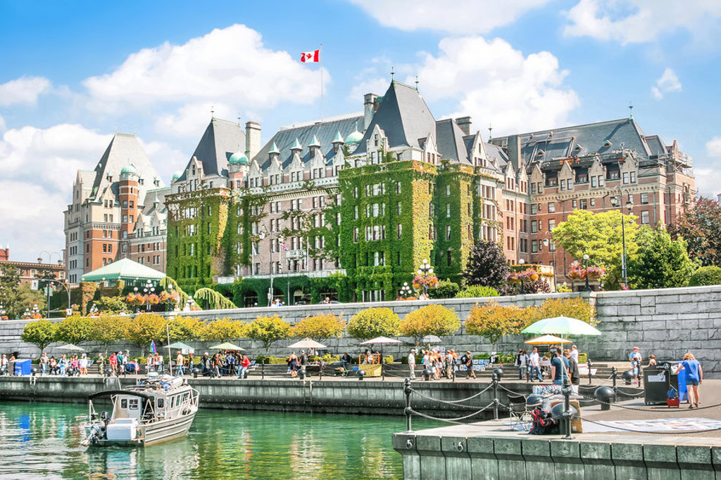 Fairmont Empress Hotel aan de Inner Harbour in Victoria, Canada, met Canadese vlag en promenade.